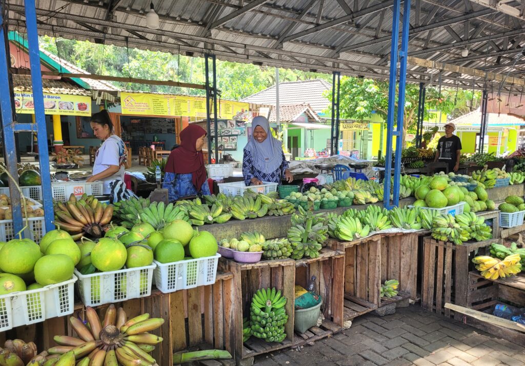 Women selling fruits and vegetables in a market. 