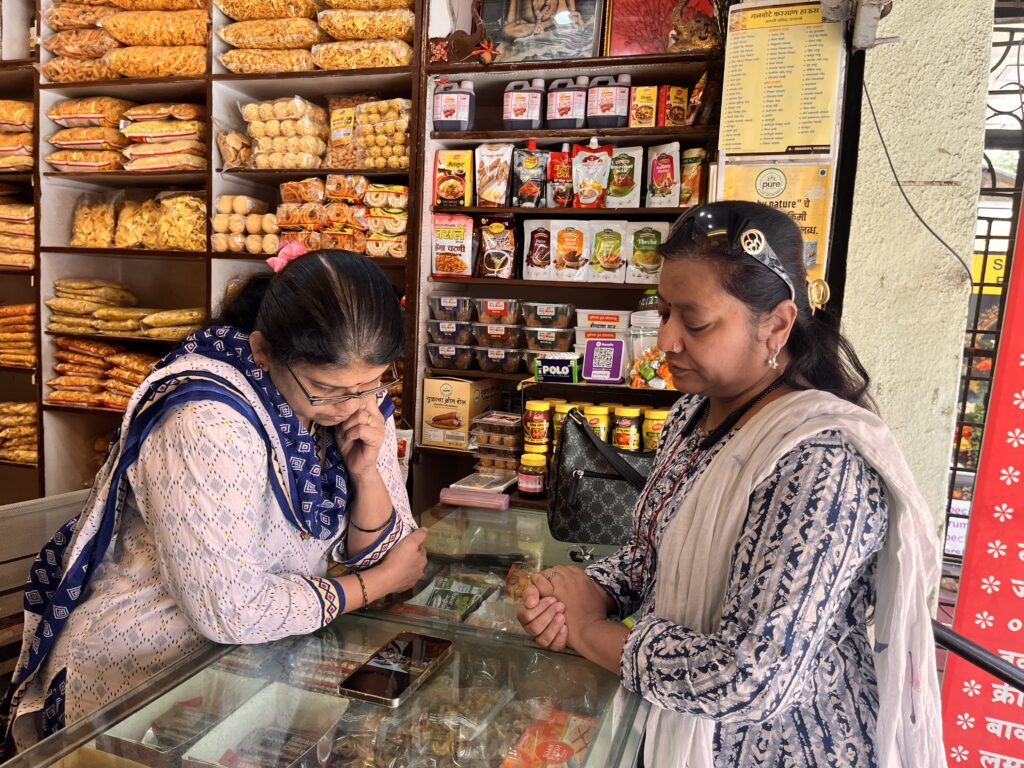 A woman showing another woman a training video on her mobile phone. 