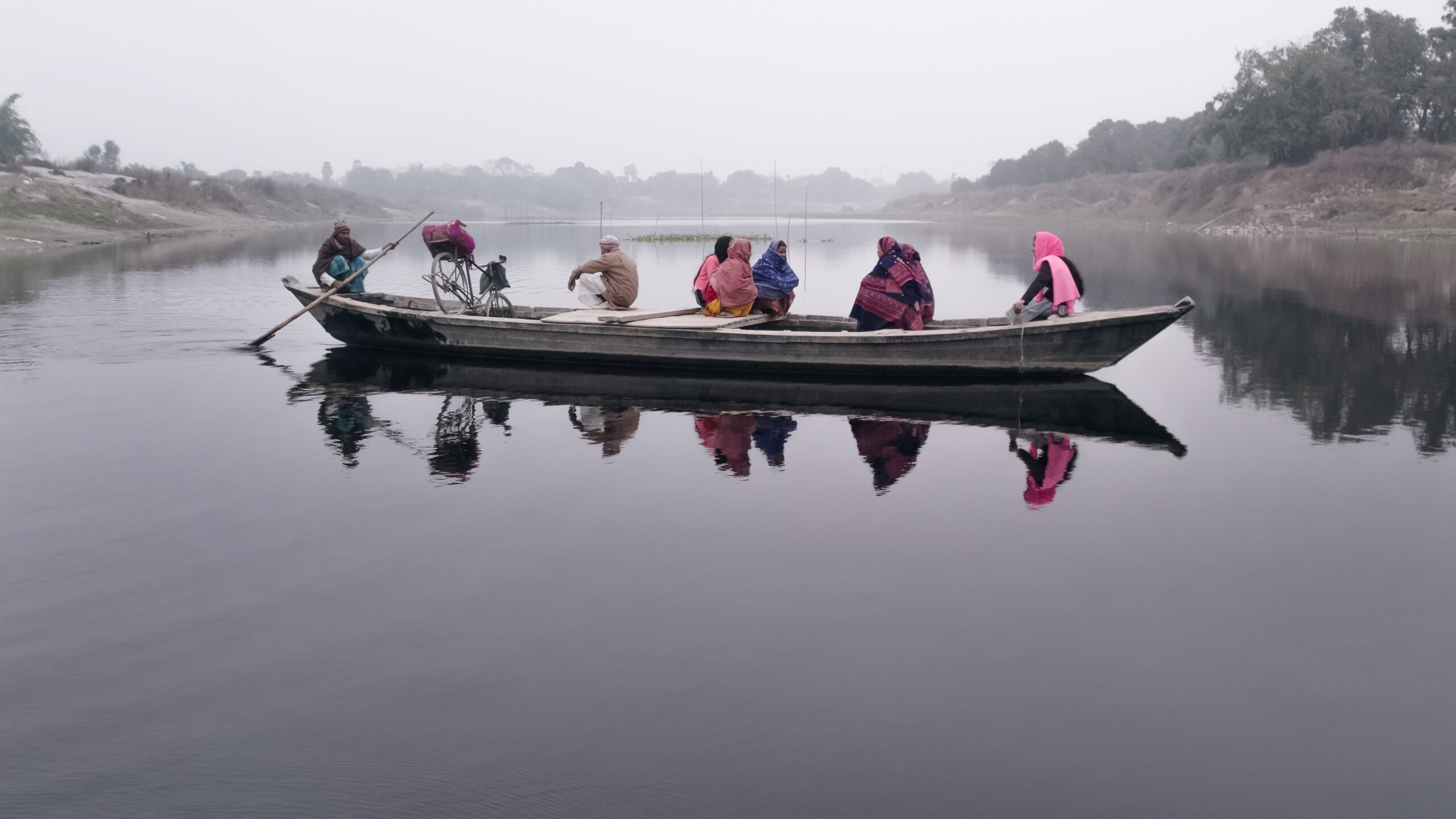 Women sitting on a boat and crossing river. 