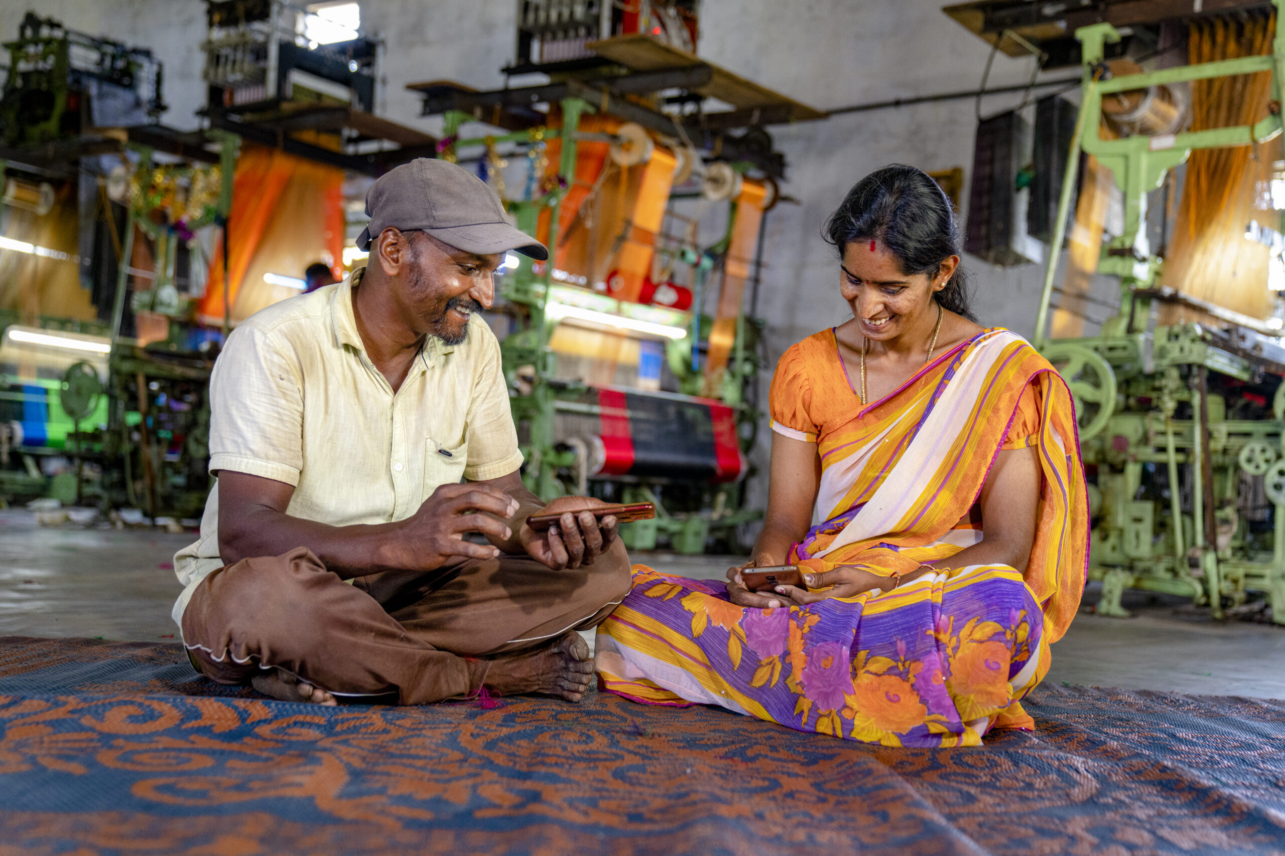 A man and a woman using their mobile phones.