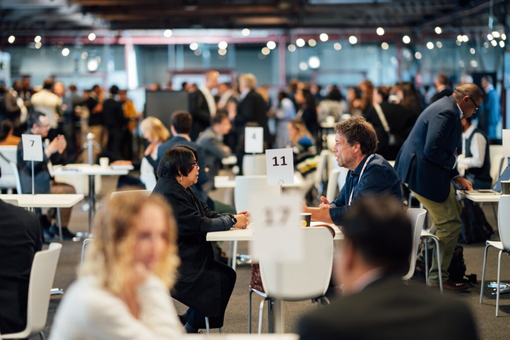 several groups of people sit at different small table and chat