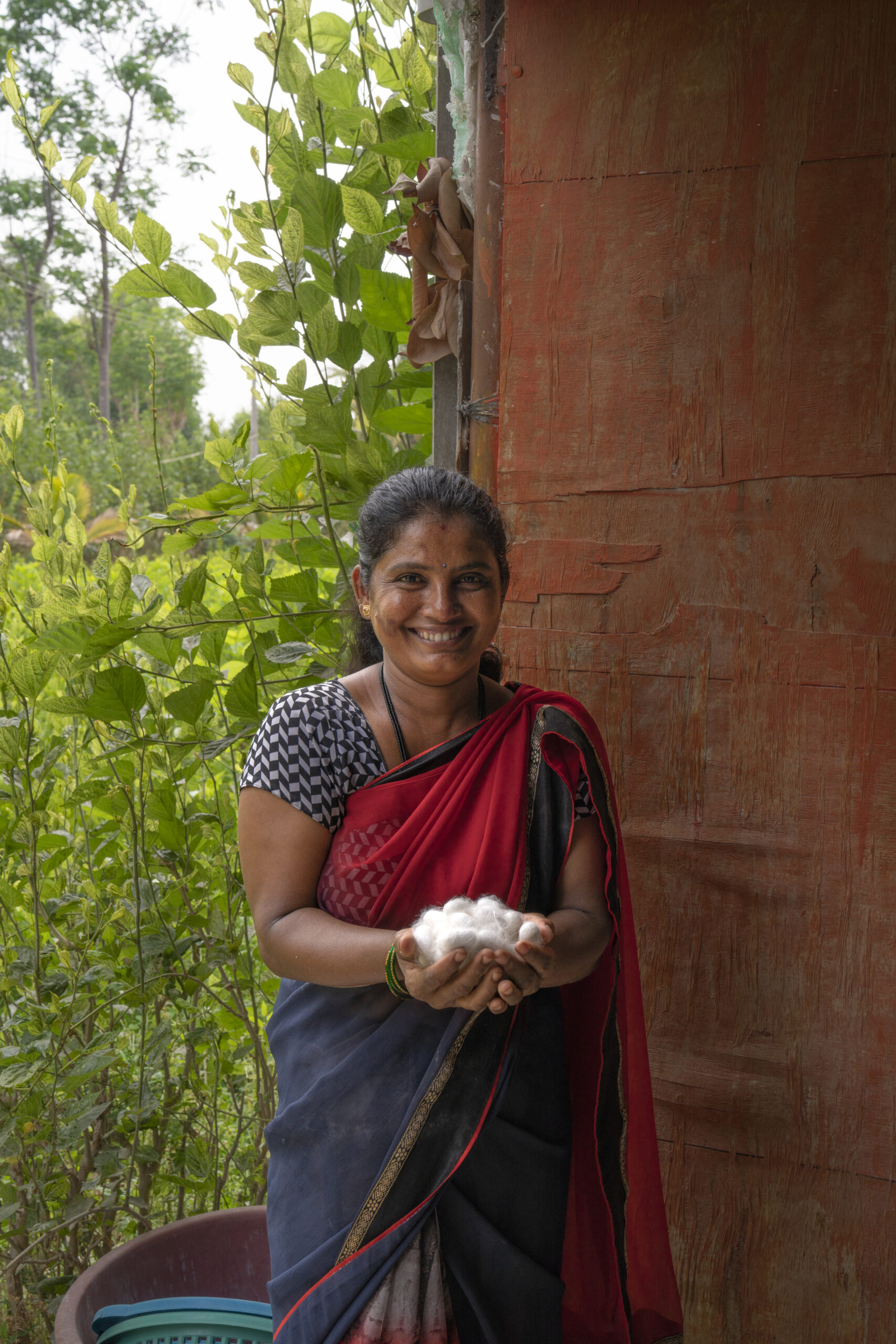 A woman holding a pile of cocoons.