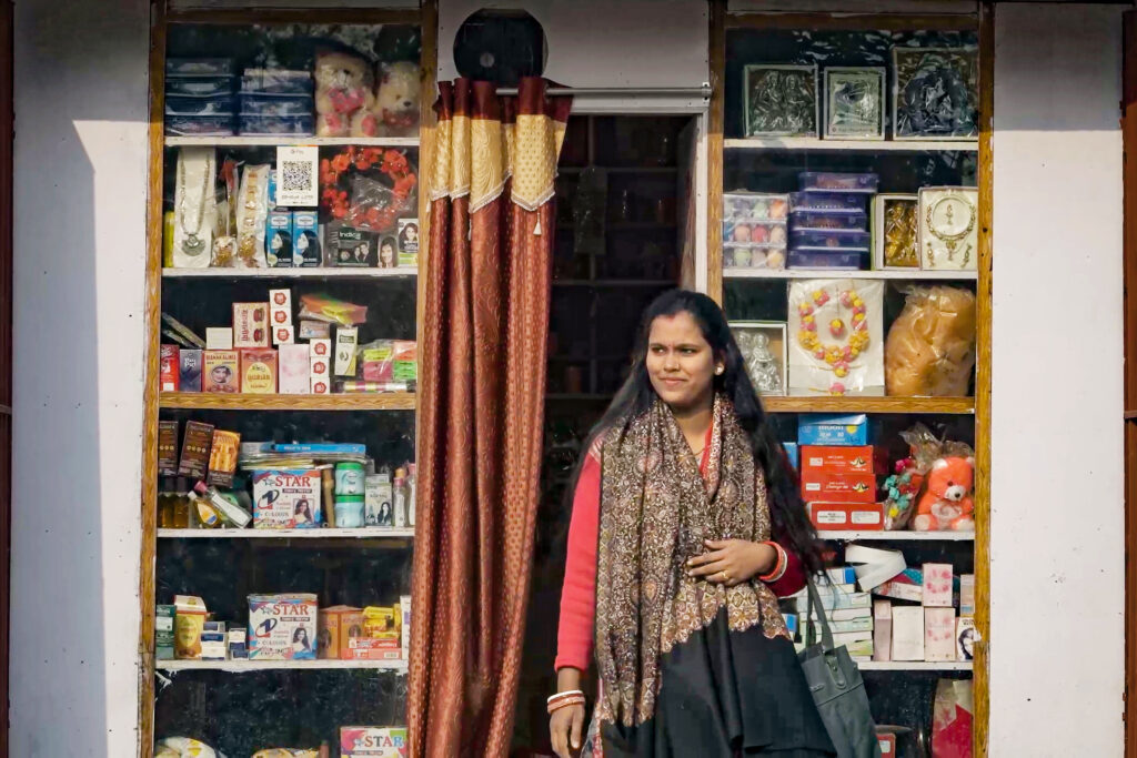 Priya stands in front of her small shop in India